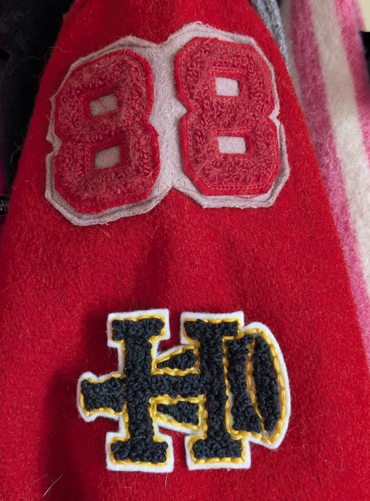 The cheer patch next to an authentic vintage varsity patch