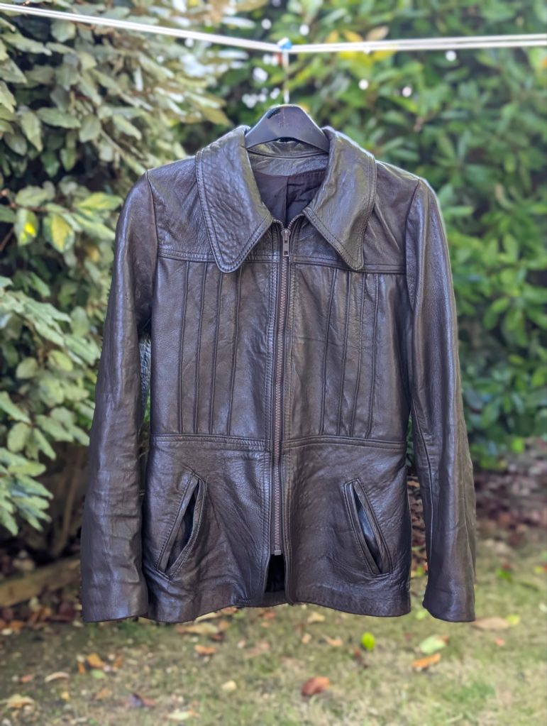 A 1970s brown leather jacket hanging to dry on a washing line after being in the washing machine